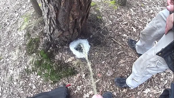 Neue Jungen, die zusammen eine große schaumige Pfütze an einem Baum pissencoole Videos